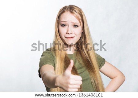 Young beautiful woman shows thumbs up sign. Body language concept.
