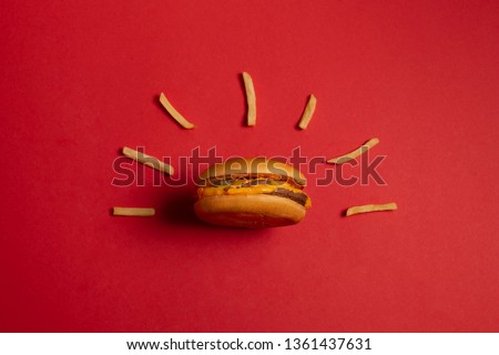 McDonald's menu: French fries and burger on red background. Minimal concept Royalty-Free Stock Photo #1361437631