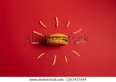 McDonald's menu: French fries and burger on red background. Minimal concept Royalty-Free Stock Photo #1361437649