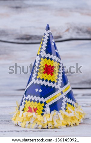 Carnival cone hat on wooden background. Kids paper accessory for special occasion.