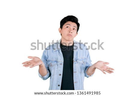 Picture of handsome man looks confused and standing with posing shrug in the studio, isolated on white background