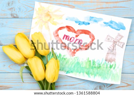 Greeting card for Mothers Day with yellow tulips on blue wooden table