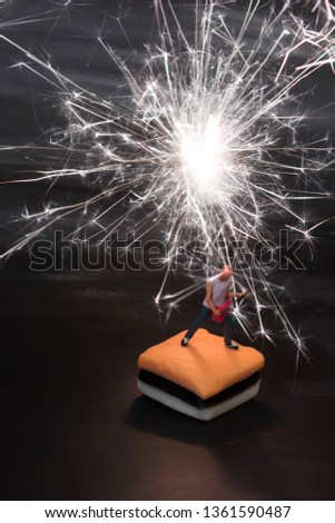 Miniature guitar solo man on black electric lightening background.Rock music and pyrotechnics concept.Little dude makes a big sound. Musician jamming is having a blast creating high energy loud music.