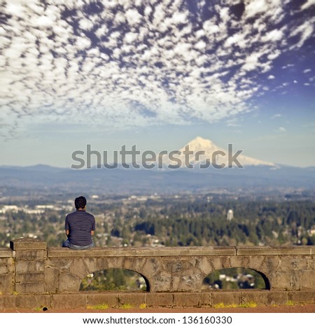 The Man sitting on the wall to watch the nature