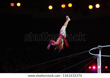 Performance of air acrobats in the circus. Acrobats perform exercises on the bar in the Circus arena