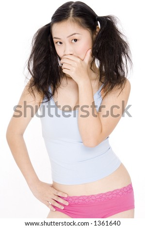 A young asian woman in bunches hides her mouth to whisper