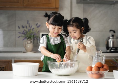 Happy Asian kids are preparing the dough, bake cookies in the Kitchen. bakery  concept. Royalty-Free Stock Photo #1361689712