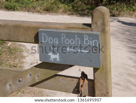"Dog Pooh Bin" Sign Attached to a Wooden gate in the Garden at Tremenheere in Rural Cornwall, England, UK

