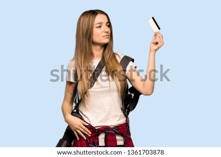 Young photographer woman taking a credit card without money on isolated blue background