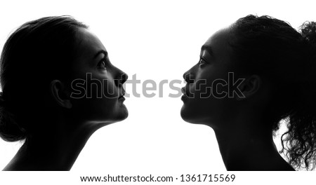 Silhouettes of a white woman and a black woman.