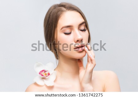 Natural blonde girl with health skin and with orchid on back posing on photo!