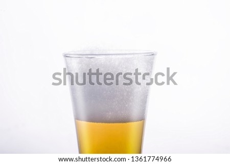 A golden refreshing glass of beer with foamy head