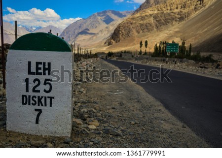 A milestone at Hunder village in Nubra Valley Ladakh showing distance from Leh in Kashmir India