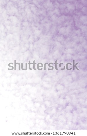 Beautiful and unusual floccus clouds in the morning spring sky. White soft cloud texture on violet sky background. Toned image