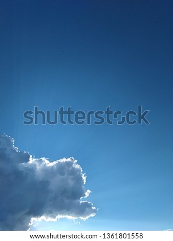 In the blue sky from under a rain cloud the rays of the sun are sparkling. Spring sky flotography.