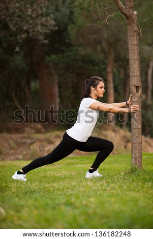 young beautiful woman stretching outdoors