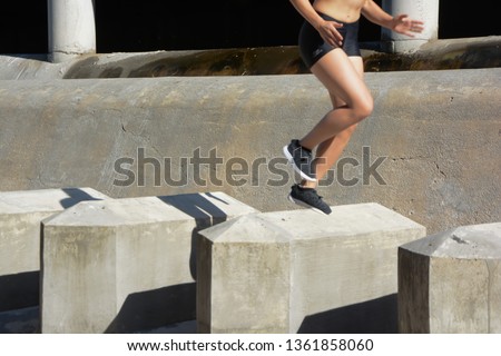 Woman running, jumping obstacles, without showing her face, with space for text
