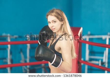 Woman on the boxing ring.The girl stands in the corner of the ring , resting between rounds with his hands on the ropes
