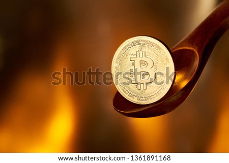 Bitcoin on spoon feeding on fire background