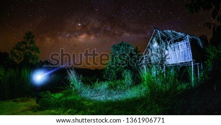Beautiful milkyway over the outdated hut in the middle of night at Muadzam Shah, Pahang, Malaysia ( Visible noise due to high ISO, soft focus, shallow DOF, slight motion blur)w