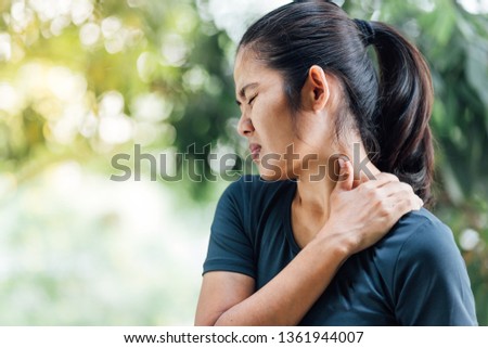 Young Asian woman with pain in shoulder , Ache in human body , health care concept Royalty-Free Stock Photo #1361944007