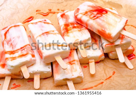 strawberry and vanilla  popsicle with red dressing on paper background