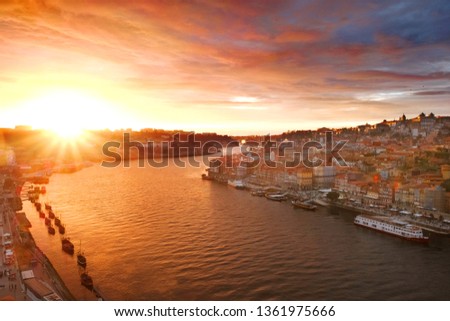 
colorful and beautiful sunset, illuminates with light and rays of the city of Porto on the Douro River in Portugal