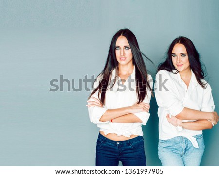 two sisters twins posing, making photo selfie, dressed same white shirt, diverse hairstyle friends, lifestyle people concept