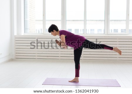 Sport, yoga, people concept - Sporty middle-aged woman practicing yoga indoors