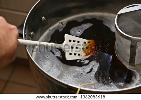 A man brewing craft beer in a kitchen. Home brewing concept image. 