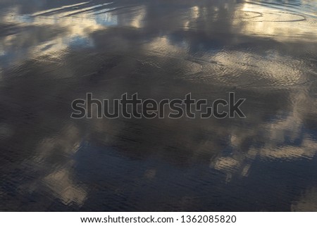Evening sky reflected in a thin layer of water in the low tide