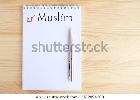 Muslim - checkbox with a red checkmark on white paper with pen. Checklist concept.