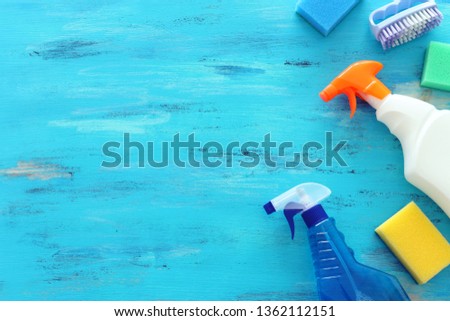 Spring cleaning concept with supplies over wooden background. Top view, flat lay