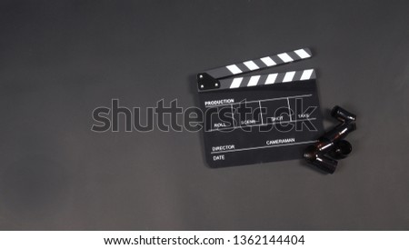 Black Clapperboard or clap board or movie slate with film use in video production ,film, cinema industry on black background.

