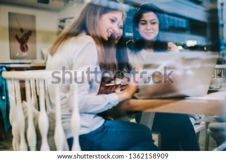 Prosperous young women smiling during watching motivation webinar using 4g wireless internet on laptop computer, happy successful female friends reading received email via application on netbook