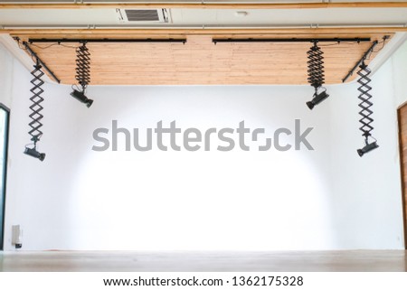 The professional studio hall hang the LED light form wood ceiling with the infinity white wall behind.