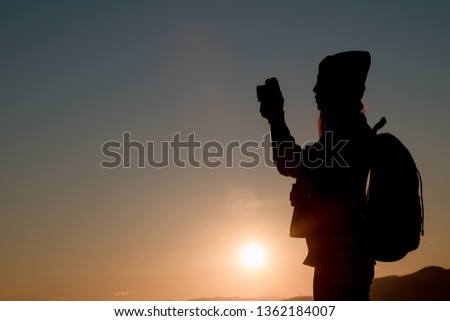 The photographer's silhouette with his camera on a sunset