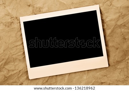 blank instant photo frame on an old paper background Royalty-Free Stock Photo #136218962