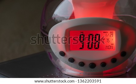 Digital electronic alarm clock that changes colors, close-up.