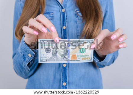 Close up cropped photo of hands with pink bright vivid manicure holding new paper banknote isolated grey background