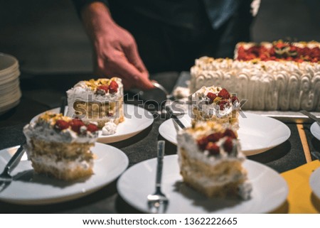 Strawberry and cream birthday cake served by the waiter in ceramic dishes