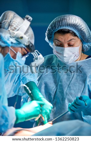 Team of surgeons makes an invasive operation. Portrait of surgeons close-up. Work with a coagulating instrument, vascular coagulation Royalty-Free Stock Photo #1362250823