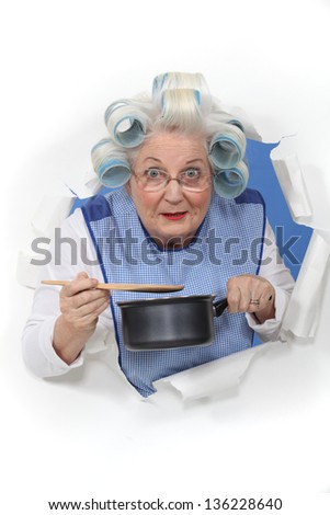 Elderly lady stirring sauce pan