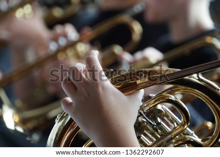 French horn and child hands. Musical brass instruments, adults and children. Concert in the school. Beautiful Festive Background. Royalty-Free Stock Photo #1362292607