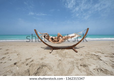 view of nice girls swinging in hummock on sea beach
