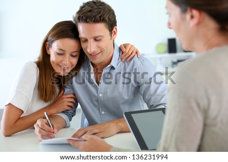 Couple signing real-estate contract Royalty-Free Stock Photo #136231994