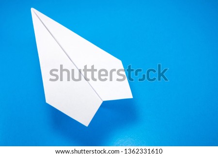 paper airplane made of white paper on a light blue background, copy space, mock up