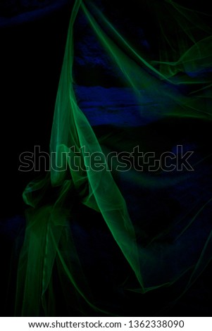 green fabric on black background backlit