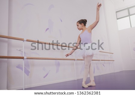 Full lenght shot of a young girl ballerina dancing at ballet school, copy space. Adorable little ballerina enjoying dancing ballet. Education, elegance, childhood concept