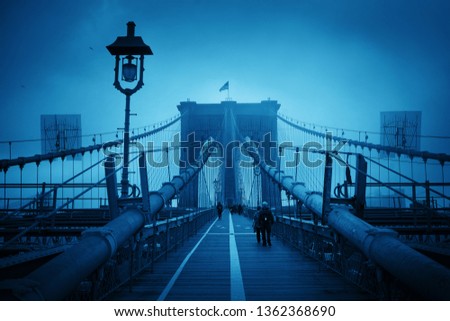 Walk on Brooklyn Bridge in a foggy day in downtown Manhattan New York City.